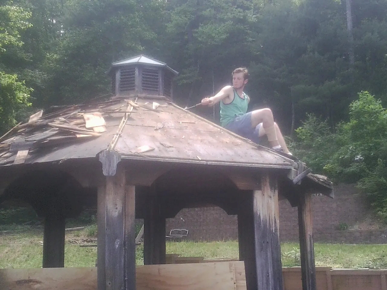 Tearing the old roof off a wooden gazebo before new shakes in Whitehall