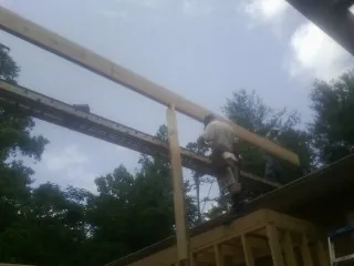 Carpenter setting a ridge beam over a new addition frame — Ice Dam Removal by Roofing Brothers in Whitehall