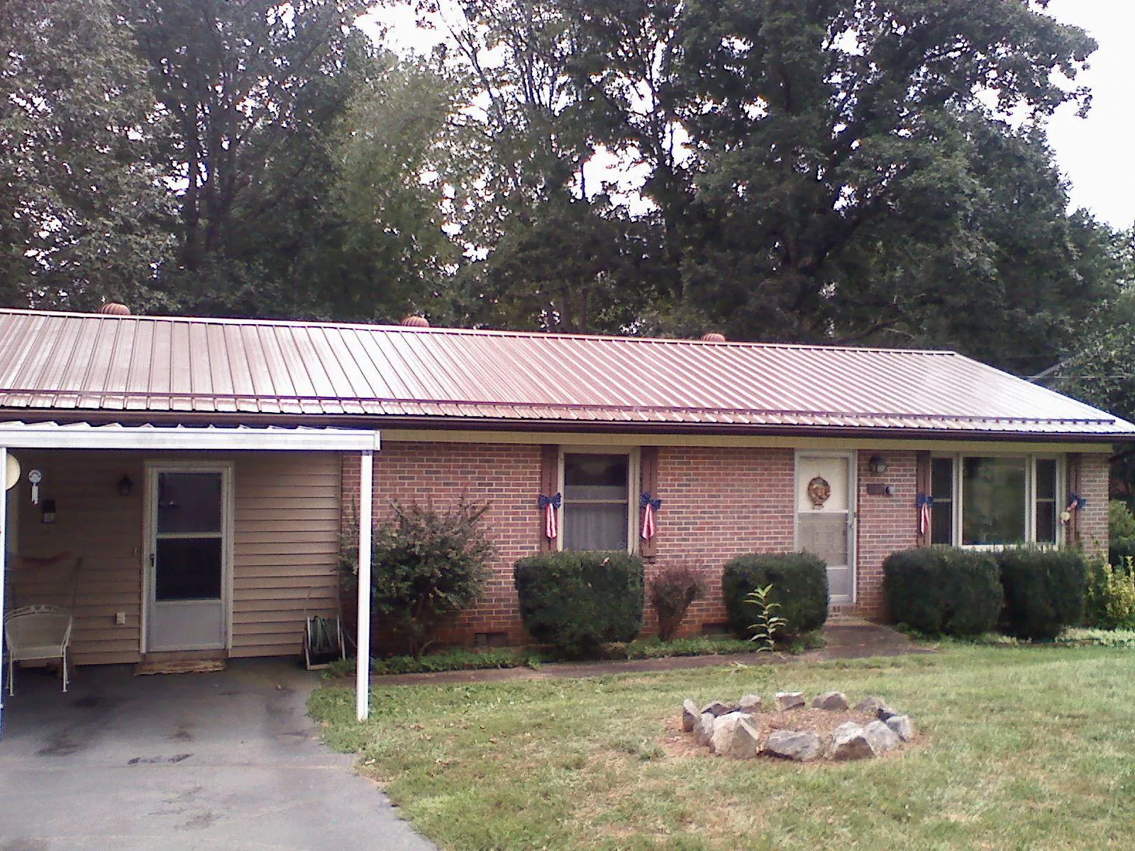 Bronze metal roof and carport on a brick ranch home — Roof Repair work by our crew in Whitehall